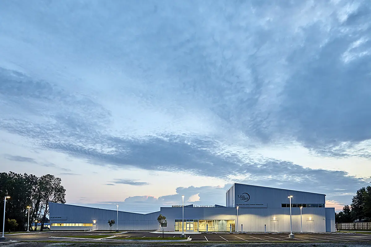 Modern building with corrugated metal exterior and large windows. "Hardesty Center for Dance Education" and "Tulsa Ballet" logos are visible. Overcast sky.