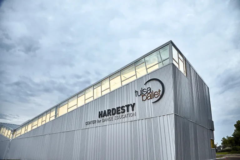 Silver building with "Hardesty Center for Dance Education" and "Tulsa Ballet" logos, under an overcast sky, reflecting a modern, artistic vibe.
