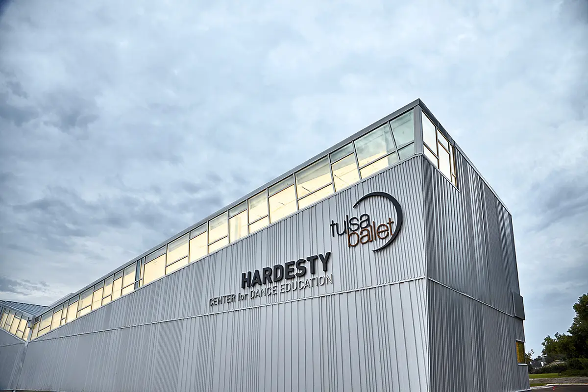 Silver building with "Hardesty Center for Dance Education" and "Tulsa Ballet" logos, under an overcast sky, reflecting a modern, artistic vibe.